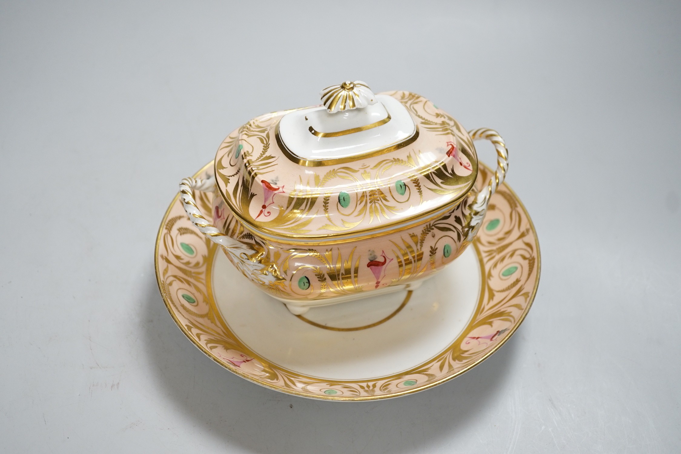 A 19th century Derby sucrier and cover and a matching saucer dish decorated in neo-classical style on a salmon coloured ground, red mark. 15cm tall overall